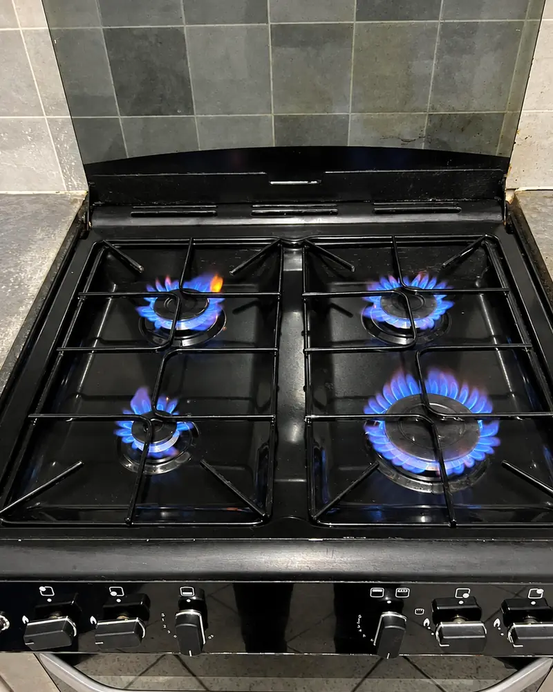 The same Belling gas hob after cleaning, hob top and pan supports clean and all four burners lit